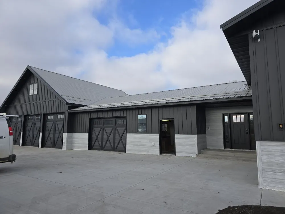 Modern farmhouse exterior with charcoal board-and-batten and three-bay barn-style garage — the Tappen Project.