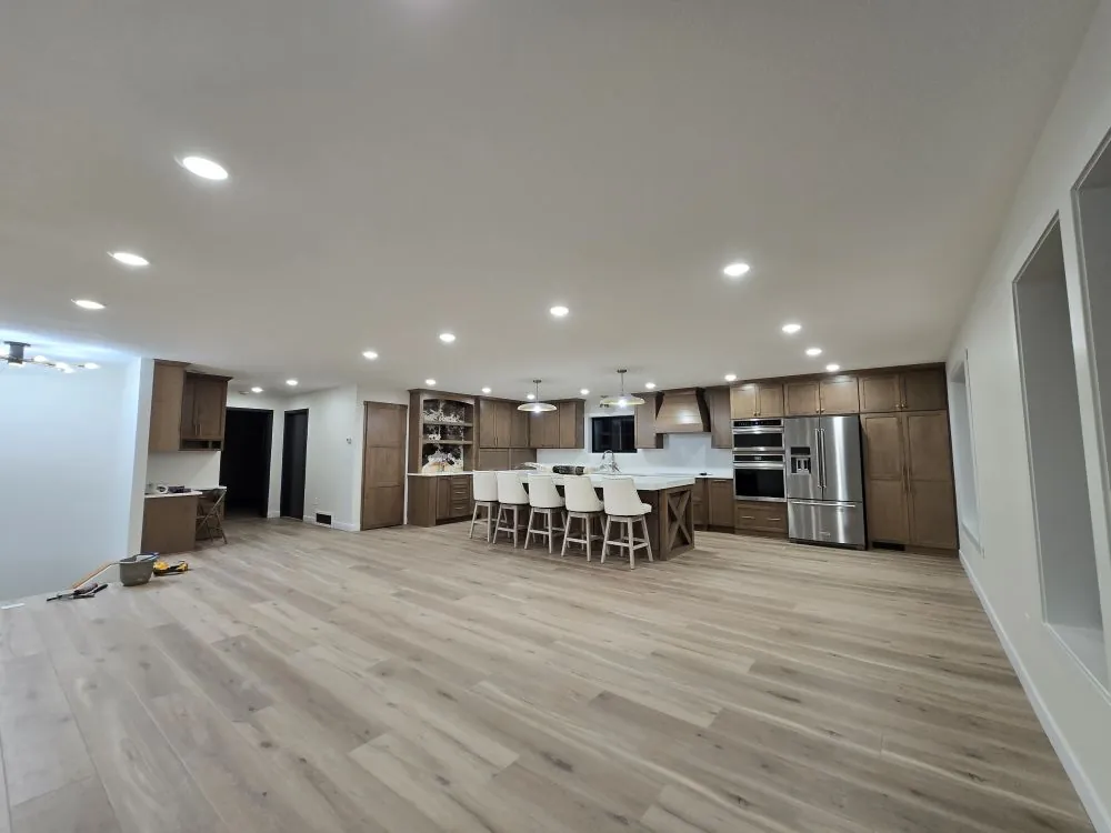 Open-concept kitchen with custom maple cabinets, large island, and stone countertops — the Tappen Project.